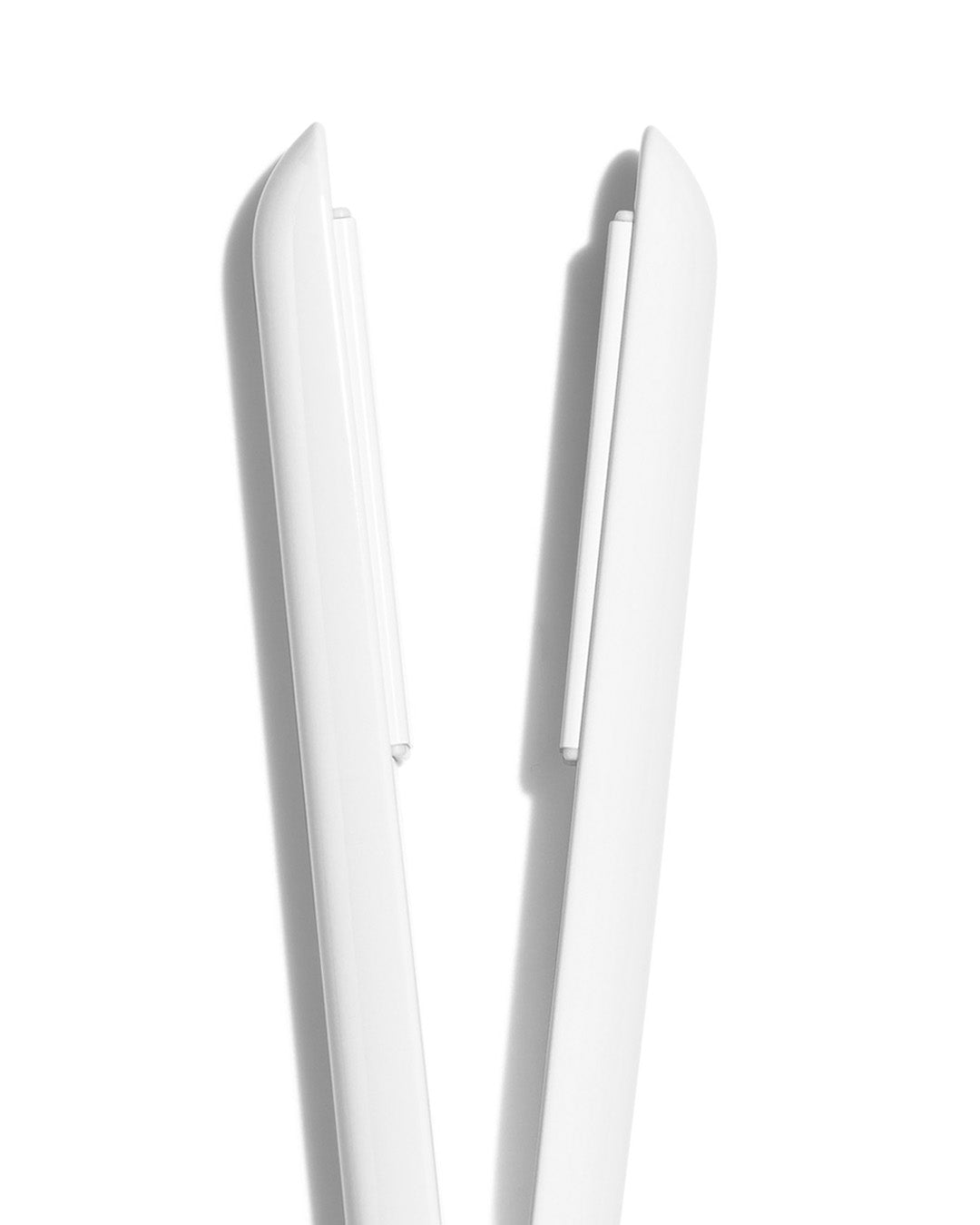 Close-up of a white hair straightener on a white background